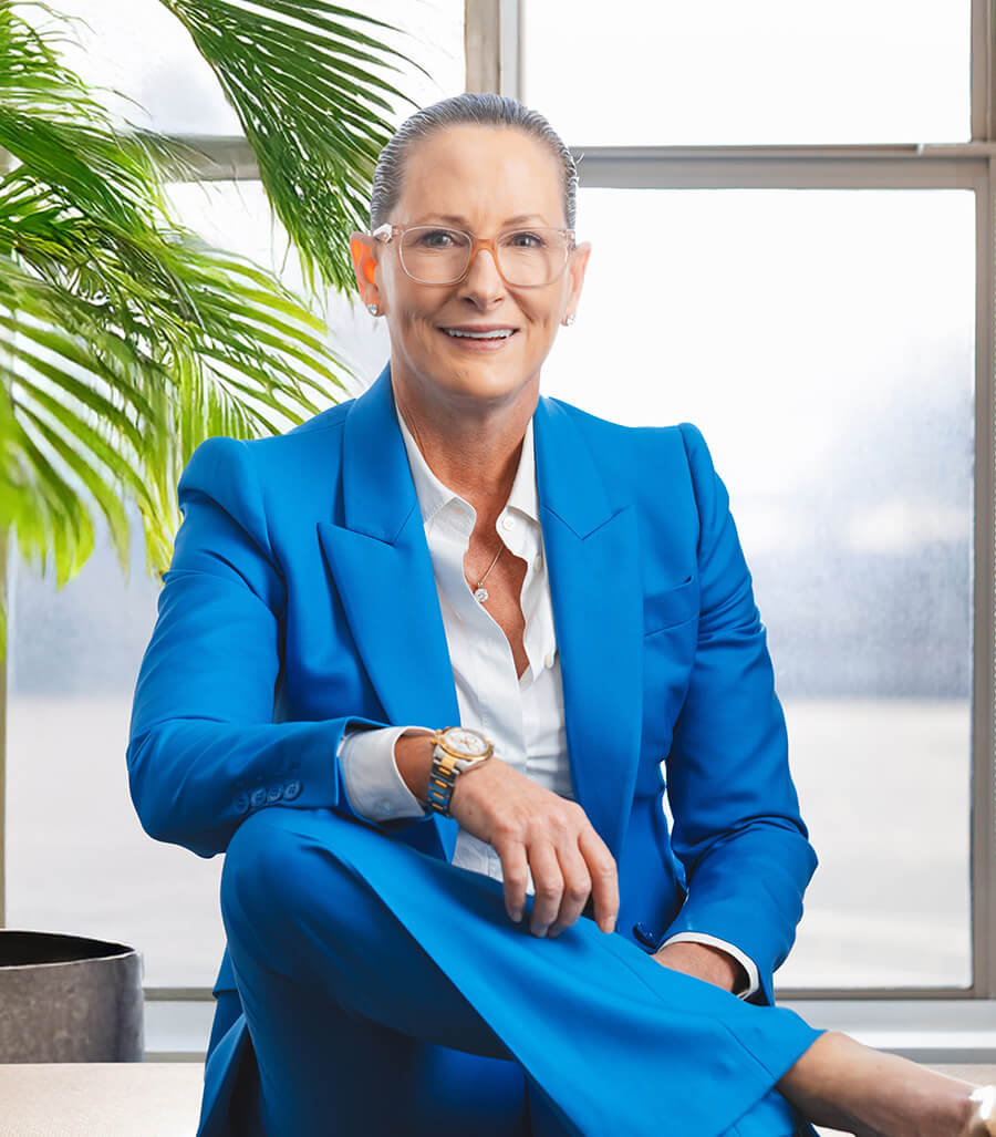 Dr. Flint in a blue suit sitting by a window