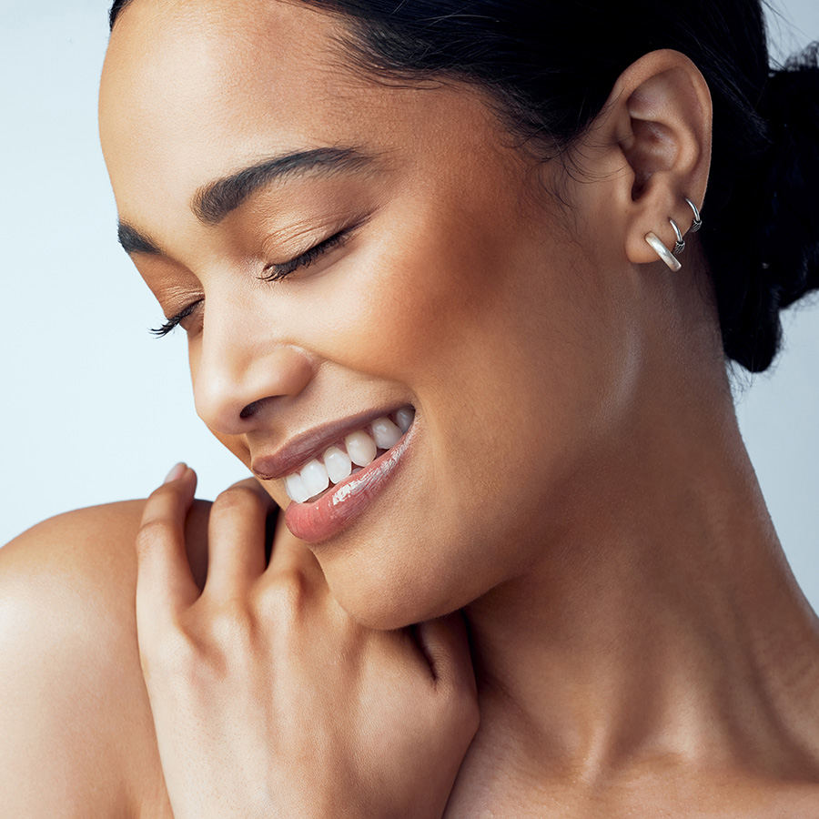 Woman smiling with her hand on her shoulder