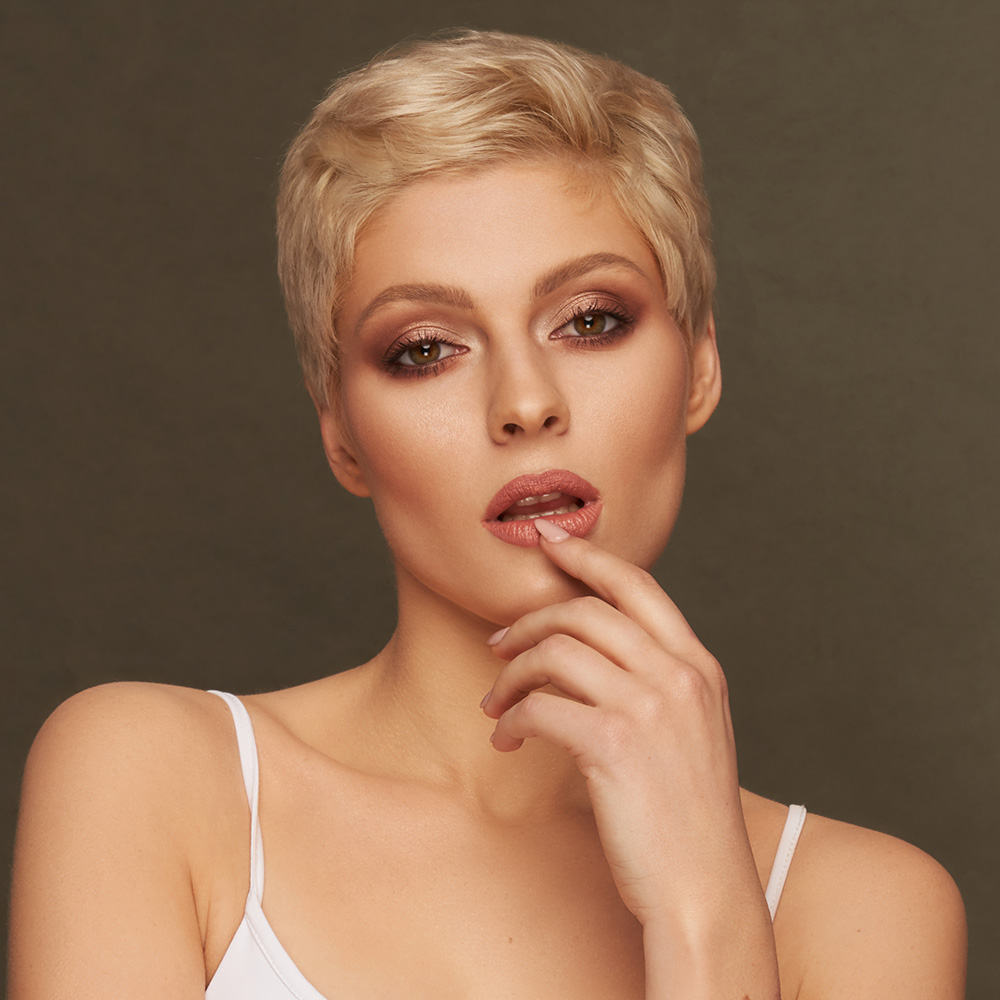 Mature woman with short hair touching her lip